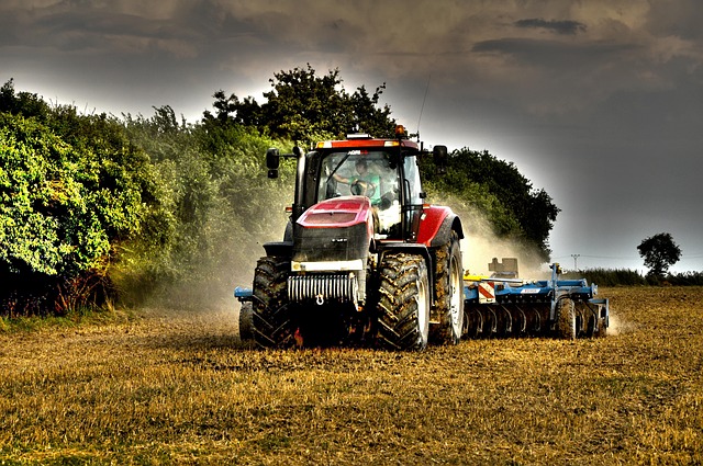 irish farmer checking tractor machinery in field service review context